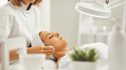 Esthetician performing facial treatment with disposable supplies in spa setting