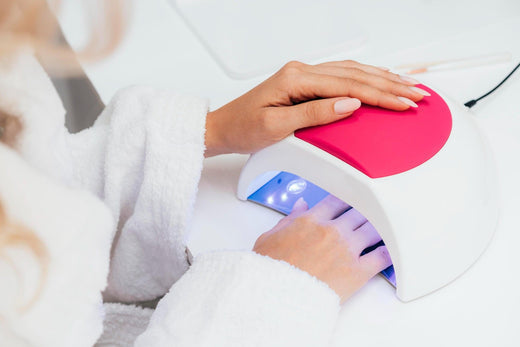 Woman using UV LED nail lamp for gel manicure in a salon setting